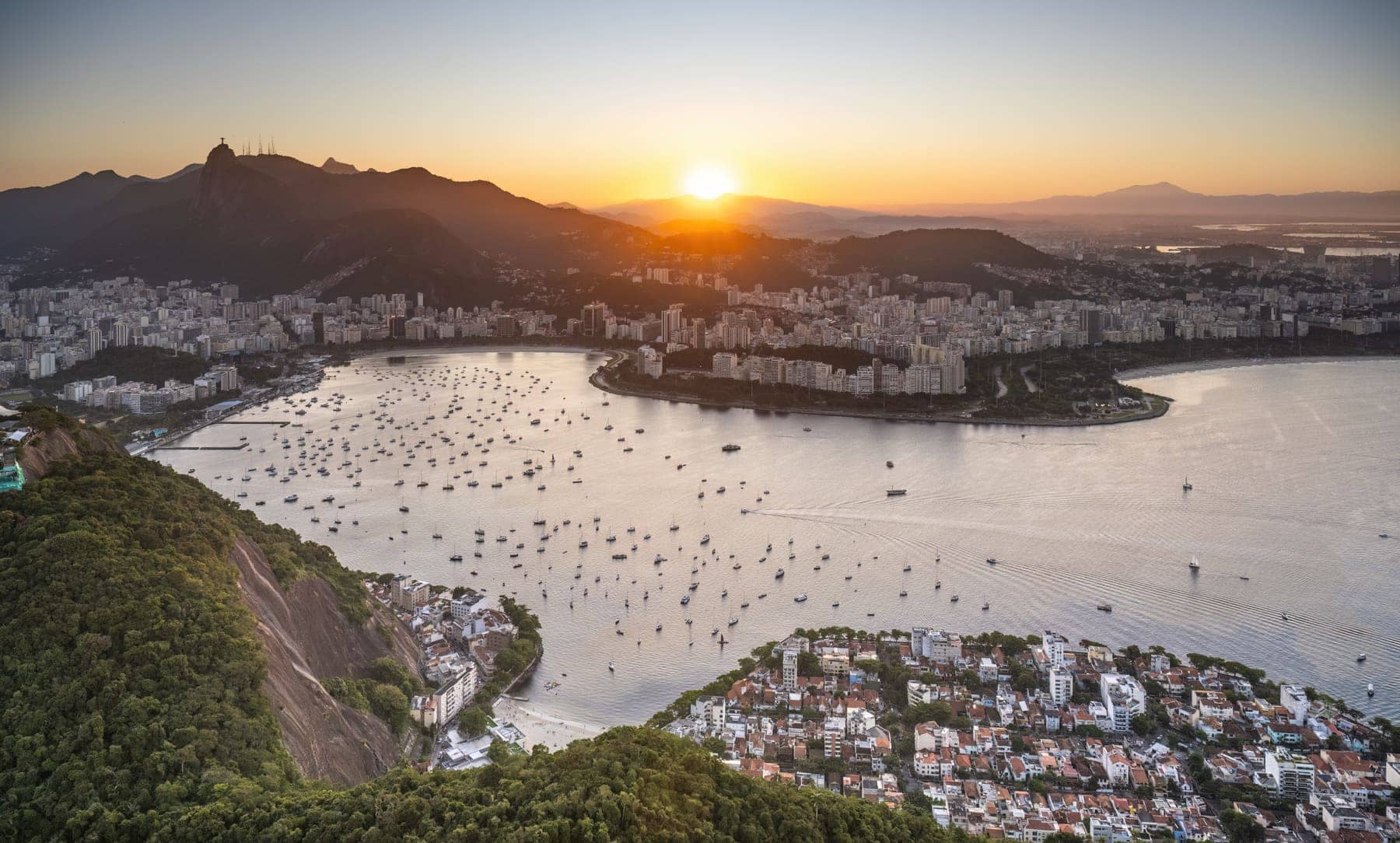 Sunset over Botafogo Bay and the Rio de Janeiro skyline, with Christ the Redeemer on the mountain ridge in the distance