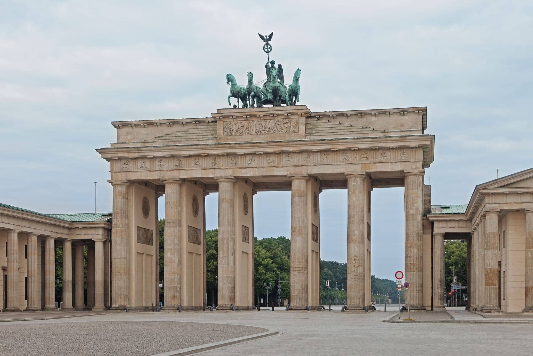 The Brandenburg Gate in Berlin with its quadriga on top, seen in morning light with an empty square