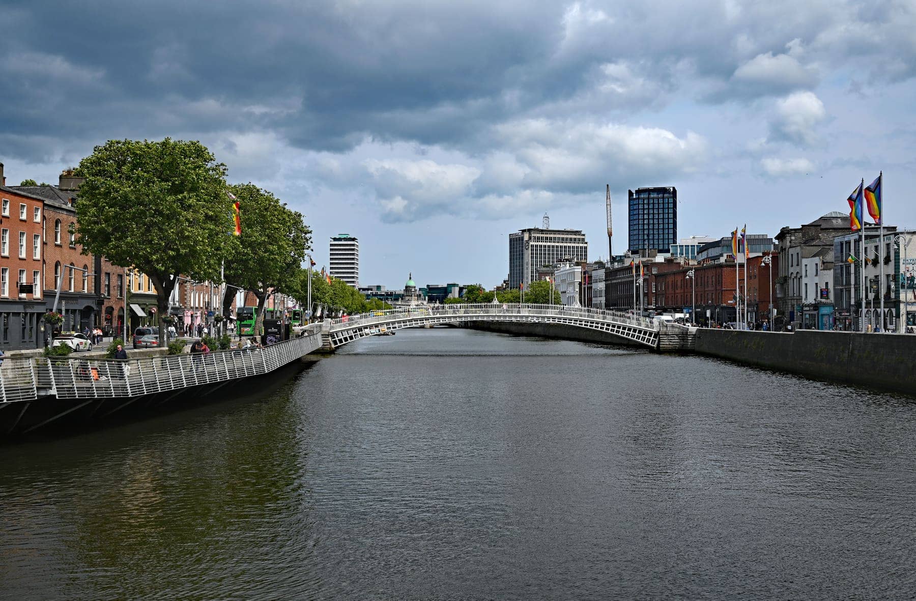 The River Liffey in Dublin with the Ha'penny Bridge in the distance and brick buildings along the quays