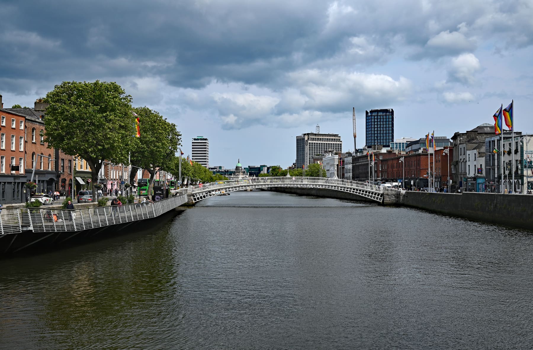 The River Liffey in Dublin with the Ha'penny Bridge in the distance and brick buildings along the quays