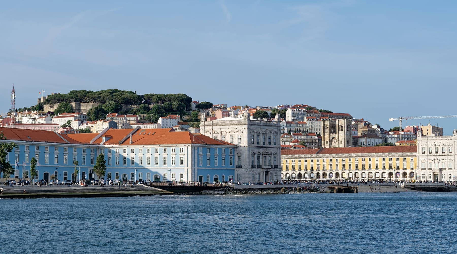 The Praça do Comércio buildings on the River Tagus waterfront in Lisbon, with the hill of Castelo de São Jorge behind