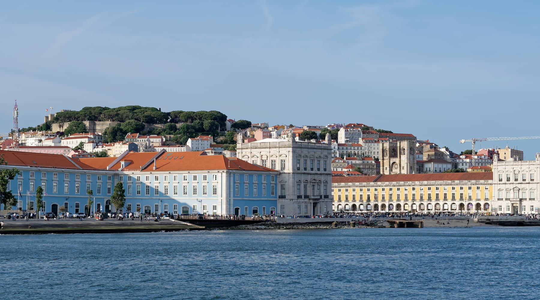 The Praça do Comércio buildings on the River Tagus waterfront in Lisbon, with the hill of Castelo de São Jorge behind
